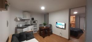 a living room with a couch and a kitchen at Au relais des ballons in Saint-Maurice-sur-Moselle