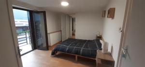 a bedroom with a bed and a large window at Au relais des ballons in Saint-Maurice-sur-Moselle