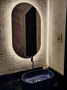 Un baño con un gran espejo y una bañera azul. en Loft do Bosque, en Ananindeua