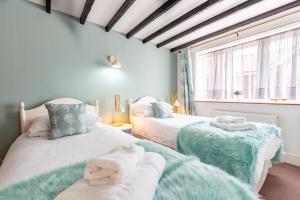 een slaapkamer met twee bedden met handdoeken erop bij Valley Farm Holiday Cottages in Axminster +39 foto's