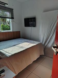 a bedroom with a bed and a tv on a wall at Loft do Bosque in Ananindeua +68 photos