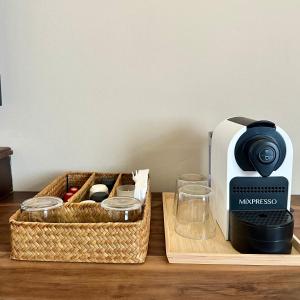a coffee maker sitting next to a basket on a table at La Pala Suites in Las Terrenas