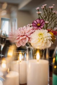 a vase with flowers and candles on a table at Ferienwohnung Ella in Dinkelsbühl