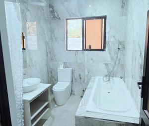a bathroom with a tub and a toilet and a sink at Canvas Luxury Villas in Lusaka +17 photos