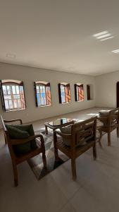 Un comedor con mesa y sillas y ventanas. en Casa Rosada temporada em Rio de Contas, en Rio de Contas 13 fotos más