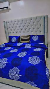 uma cama azul com lençóis e almofadas azuis em A well-built 2 bedroom duplex em Lekki