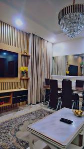 uma sala de estar com uma mesa de jantar e uma televisão em A well-built 2 bedroom duplex em Lekki