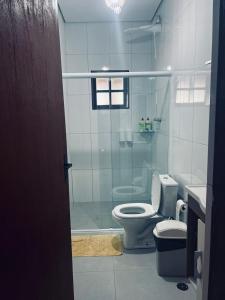 Un baño con inodoro y ducha de cristal. en Sítio Lopes, en Toledo