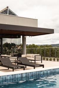 GuaporéにあるMonaro Hotel Guaporéのラウンジチェア付きのスイミングプールが隣接しています。