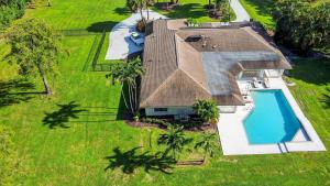 an aerial view of a house with a swimming pool at Palm Beach Polo & PGA Retreat - Pool & Luxe Comfort in Wellington