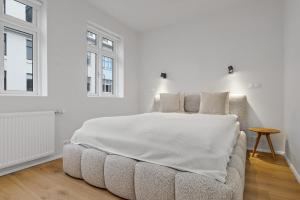 雷克雅未克Downtown Apartment with Parking的一间带床和椅子的白色卧室 更多14张照片