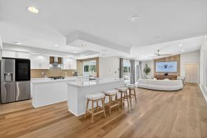 an open kitchen and living room with a large island at Palm Beach Polo & PGA Retreat - Pool & Luxe Comfort in Wellington