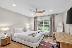 a bedroom with a bed and a desk and a window at Palm Beach Polo & PGA Retreat - Pool & Luxe Comfort in Wellington
