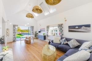 een woonkamer met een blauwe bank en een tafel bij Valley Farm Holiday Cottages in Axminster