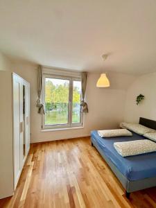 a bedroom with two beds and a large window at Spacious Modern Apartment with Free Parking in Gerasdorf bei Wien