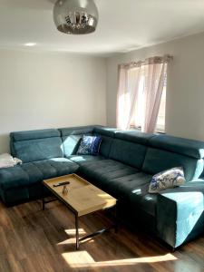 a living room with a green couch and a coffee table at Apartment Versteck am Hug in Jüterbog