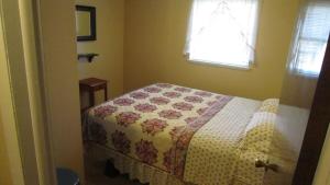 Un dormitorio con una cama con una colcha encima en The Oak Ridge House, en Zanesville