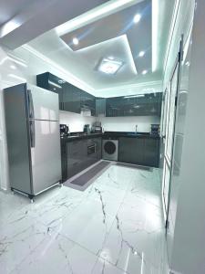 a kitchen with white marble floors and a refrigerator at Appartement Casa in Essaouira