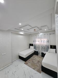 a bedroom with two beds and a rug at Appartement Casa in Essaouira