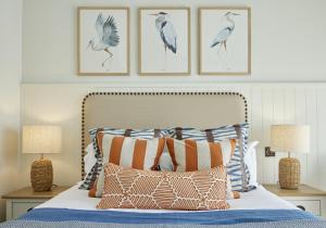 a bedroom with a bed with three pictures on the wall at St Brides Spa Hotel & Village Apartments in Saundersfoot +99 photos