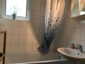 ein Badezimmer mit Badewanne und Waschbecken und einem Fenster in der Unterkunft Moderne Ferienwohnung - Top Lage nahe Skigebiet & Wanderwegen in Sankt Andreasberg
