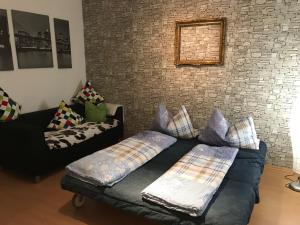 ein Wohnzimmer mit einer Couch und einer Ziegelwand in der Unterkunft Moderne Ferienwohnung - Top Lage nahe Skigebiet & Wanderwegen in Sankt Andreasberg