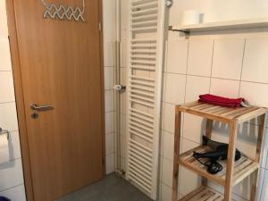 ein Badezimmer mit Tür und Regal und ein Zimmer in der Unterkunft Moderne Ferienwohnung - Top Lage nahe Skigebiet & Wanderwegen in Sankt Andreasberg + 19 Fotos