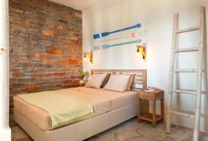 a bedroom with a bed and a brick wall at Sea & Stone Villas in Koundouros +37 photos