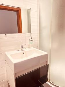 een badkamer met een witte wastafel en een spiegel bij CityGate Kraków in Krakau