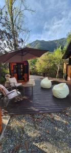 a patio with a table and chairs and an umbrella at Cabaña Serrano in Linares