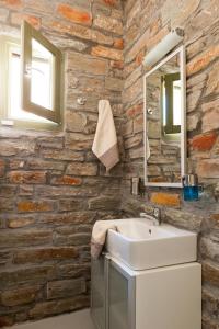 a bathroom with a sink and a stone wall at Sea & Stone Villas in Koundouros +25 photos