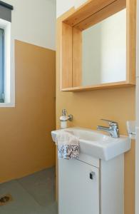 a bathroom with a sink and a mirror at Sea & Stone Villas in Koundouros