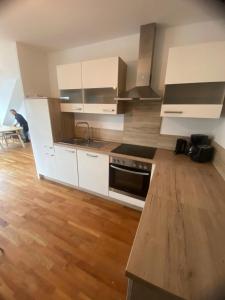 a kitchen with white cabinets and a wooden floor at Luxury Apartment with Balcony & Free Parking in Vienna
