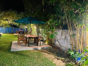 uma mesa e cadeiras com um guarda-sol num quintal em Sun and Moon spa em Tangalle mais 18 fotografias
