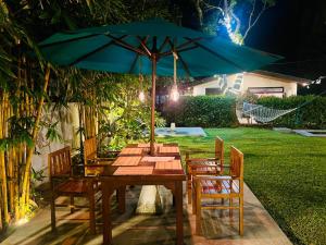 uma mesa de madeira com um guarda-chuva num quintal em Sun and Moon spa em Tangalle