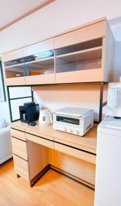 einen Schreibtisch mit einer Mikrowelle und einem Drucker darauf in der Unterkunft HYGGE HOUSE Tabibitonoie - Vacation STAY 61141v in Kashiwa + 1 Foto