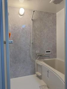 ein Bad mit einer Dusche, einer Badewanne und einem Waschbecken in der Unterkunft HYGGE HOUSE Tabibitonoie - Vacation STAY 61141v in Kashiwa