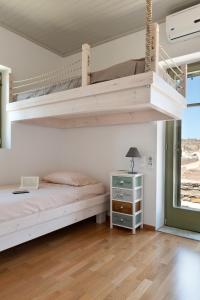 a bedroom with two bunk beds and a window at Sea & Stone Villas in Koundouros