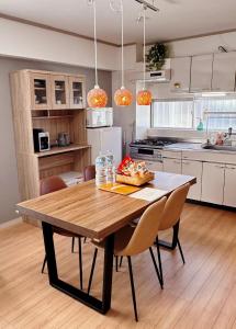 eine Küche mit einem Holztisch und Stühlen in der Unterkunft HYGGE HOUSE Tabibitonoie - Vacation STAY 61161v in Kashiwa