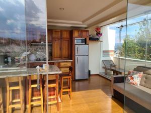 a kitchen and living room with a table and a couch at Hilltop Bellavista, Suite Three, the best choice in Cuenca