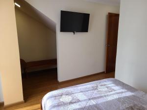 a bedroom with a bed and a tv on a wall at Hilltop Bellavista, Suite Three, the best choice in Cuenca