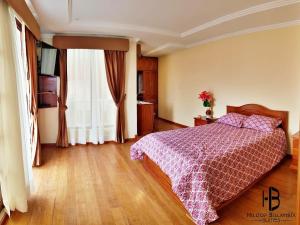 a bedroom with a bed with a purple bedspread at Hilltop Bellavista, Suite Three, the best choice in Cuenca