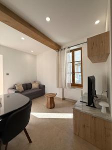 a living room with a couch and a tv at la maison du soleil in Sigean