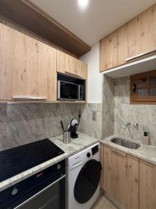 a kitchen with a stove and a microwave at la maison du soleil in Sigean +22 photos