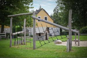 a playground with a swing set in a park at Wellness huis voor 6 personen aan het strand 'Zeeuwse Rust' in Wemeldinge