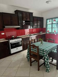 een keuken met een tafel met een groene en witte tafelkleed bij Casa Nova Montrond in São Filipe