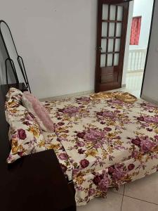 een bed met een bloemdekbed in een kamer bij Casa Nova Montrond in São Filipe