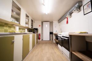 a large kitchen with wooden floors and white cabinets at 1908 Hostel by Tröll in Vík +30 photos
