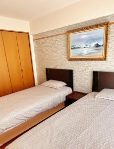 ein Schlafzimmer mit zwei Betten und einem Bild an der Wand in der Unterkunft HYGGE HOUSE Tabibitonoie - Vacation STAY 61173v in Kashiwa