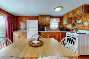 cocina con mesa de madera y nevera blanca en Little Cottage, en York